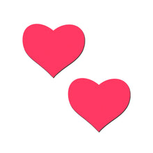Load image into Gallery viewer, A close-up of two heart-shaped neon pink Pastease nipple covers, designed for all breast shapes and sizes. Made in the USA by a family-run business, they're skin-safe, waterproof, and perfect for adding a playful, flirty touch to any outfit or occasion.