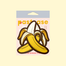 Load image into Gallery viewer, The Banana Pasties Long Yellow Nipple Covers by Pastease®. Two bananas being peeled open nipple covers in the pastease pastel packaging on a pastel yellow background. Perfect for a festival, burlesque performance, drag shows, pride or parties.