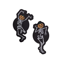 Load image into Gallery viewer, Dancing Skeletons Pasties with Pumpkin Heads Spooky Scary Skeletons nipple covers on a white background. One of the skeletons is dancing with one leg in the air and both arms up, while the other is dancing with arms bent and legs together. Both skeletons have orange spooky faced pumpkin heads.