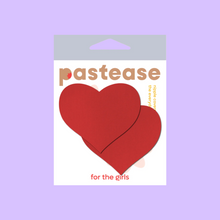 Load image into Gallery viewer, Love: Red Heart Nipple Pasties by Pastease®. Two matte red heart shaped nipple covers shown in the pastease packaging on a lilac background.