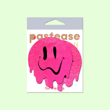 Load image into Gallery viewer, Melty Smiley Face: Neon Pink Melted Smiling Face Nipple Pasties by Pastease. Two hot pink melting drippy smiley faces nipple covers shown in pastease packaging on a pastel green background.