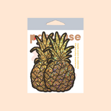 Load image into Gallery viewer, The Pineapple on Glitter Gold Nipple Covers by Pastease®. Two gold glittering shimmer pineapple nipple covers in the pastel pastease packaging on a pastel orange background. Perfect for a festival, burlesque performance, drag shows, pride or parties.