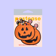 Load image into Gallery viewer, The Trick-or-Treat Pumpkin Pasties with Candy Nipple Covers by Pastease®. Two jack o lantern carved pumpkins stuffed full of various halloween candy nipple covers shown in the pastease pastel packaging on a pastel purple background. Perfect for festivals, pride, burlesque, raves, only fans content or parties.