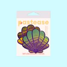 Load image into Gallery viewer, The Mermaid Shells Pasties in Opalescent Purple & Gold Seashell Nipple Covers by Pastease®. Two purple glitter with green to pink iridescent film sea shells in the pastease pastel packaging on a pastel blue background. Perfect for a festival, pride, burlesque performance, only fans content or a party.