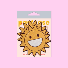 Load image into Gallery viewer, The Happy Sun Pasties Sparkling Smiling Sunshine Nipple Covers by Pastease®. Two smiling glitter velvet cartoon sunshine nipple covers shown in the pastease pastel packaging on a pastel pink background. Perfect for a festival, burlesque performance, pride or parties.