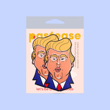 Load image into Gallery viewer, The Donald J Trump Pasties DJT Nipple Covers by Pastease in a pastease cellophane pack on a pastel blue background. Two nipple covers of donald j trump busts in a cartoon style with his orange tan, yellow blonde hair and blue suit with red tie, he is puckering his lips for a kiss. Perfect for a festival, burlesque performance, drag shows, pride or parties.