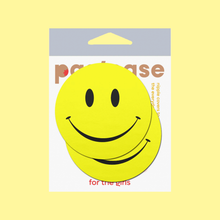 Load image into Gallery viewer, Smiley Faces: Bright Yellow Nipple Pasties by PasteaseĀ®. Two yellow smiley face nipple covers, shown on yellow background. Perfect for a festival, burlesque performance, pride or parties.
