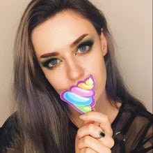 Load image into Gallery viewer, Model holding up the Unicorn Poo: Scummy Bear Rainbow Shit Emoji Nipple Pasties by Pastease to their face.