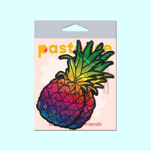 Rainbow Pineapple Sparkling Breast Pasties by Pastease® in vibrant rainbow tones on a pineapple design, displayed in branded packaging with a pastel background. Fun and flirty nipple covers made in the USA for all breast shapes and sizes, perfect for parties and festivals.