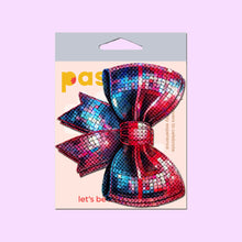 Load image into Gallery viewer, Packaging for Pastease Disco Ball Bow Sparkling Breast Pasties, featuring a vibrant red and blue sequin bow design. Made by a family-operated business in the USA, these fun and flirty nipple covers fit all breast shapes and sizes. Ideal for parties, festivals, or burlesque.
