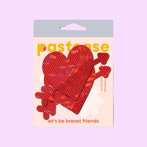 Cupid's Arrow Red Heart Breast Pasties by Pastease® in their original packaging. The design features a sparkling red heart pierced by an arrow, perfect for Valentine’s Day or romantic occasions. Fun, flirty, and designed to fit all breast shapes and sizes. Made in the USA.