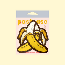 Load image into Gallery viewer, The Banana Pasties Long Yellow Nipple Covers by Pastease®. Two bananas being peeled open nipple covers in the pastease pastel packaging on a pastel yellow background. Perfect for a festival, burlesque performance, drag shows, pride or parties.
