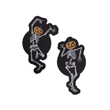 Load image into Gallery viewer, Dancing Skeletons Pasties with Pumpkin Heads Spooky Scary Skeletons nipple covers on a white background. One of the skeletons is dancing with one leg in the air and both arms up, while the other is dancing with arms bent and legs together. Both skeletons have orange spooky faced pumpkin heads.
