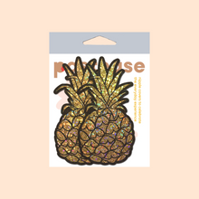 Load image into Gallery viewer, The Pineapple on Glitter Gold Nipple Covers by Pastease®. Two gold glittering shimmer pineapple nipple covers in the pastel pastease packaging on a pastel orange background. Perfect for a festival, burlesque performance, drag shows, pride or parties.
