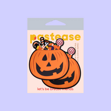 Load image into Gallery viewer, The Trick-or-Treat Pumpkin Pasties with Candy Nipple Covers by Pastease®. Two jack o lantern carved pumpkins stuffed full of various halloween candy nipple covers shown in the pastease pastel packaging on a pastel purple background. Perfect for festivals, pride, burlesque, raves, only fans content or parties.
