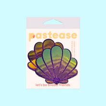 Load image into Gallery viewer, The Mermaid Shells Pasties in Opalescent Purple &amp; Gold Seashell Nipple Covers by Pastease®. Two purple glitter with green to pink iridescent film sea shells in the pastease pastel packaging on a pastel blue background. Perfect for a festival, pride, burlesque performance, only fans content or a party.
