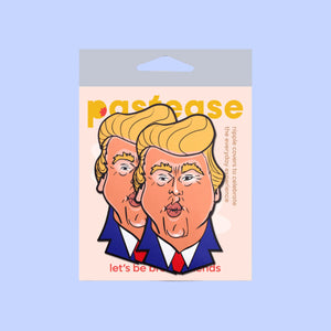 The Donald J Trump Pasties DJT Nipple Covers by Pastease in a pastease cellophane pack on a pastel blue background. Two nipple covers of donald j trump busts in a cartoon style with his orange tan, yellow blonde hair and blue suit with red tie, he is puckering his lips for a kiss. Perfect for a festival, burlesque performance, drag shows, pride or parties.