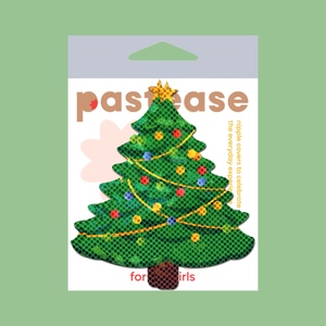 Christmas Tree Nipple Pasties by Pastease®. Two green glittery Christmas tree shaped nipple covers in packet, shown on green background. Perfect for a festival, burlesque performance, pride, Christmas or parties